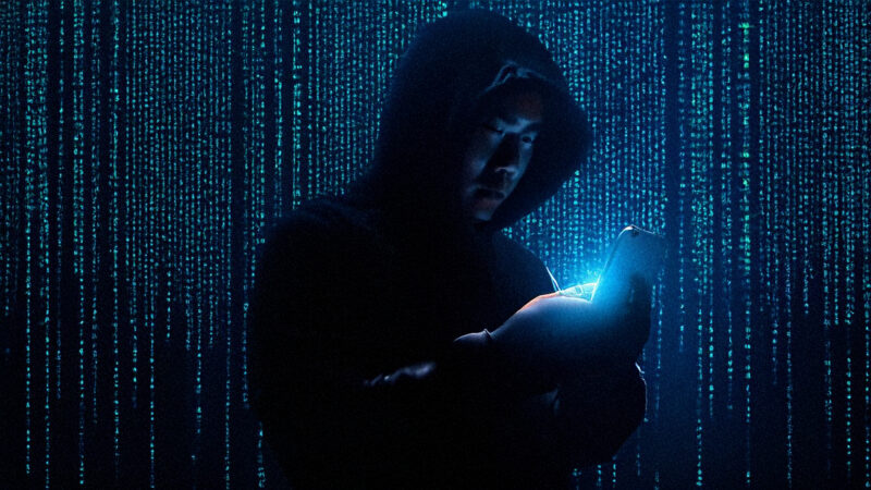 Person in a dark hoodie using a smartphone, symbolising Pegasus spyware surveillance in Europe