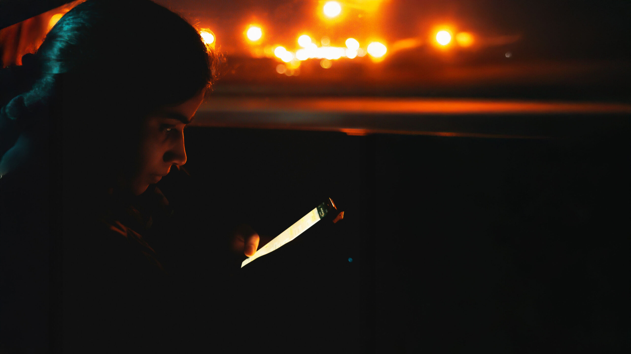 A young woman, deeply consumed by her phone, symbolising the addictive nature of the Instagram algorithm. Image from Unspalsh, credits in the references