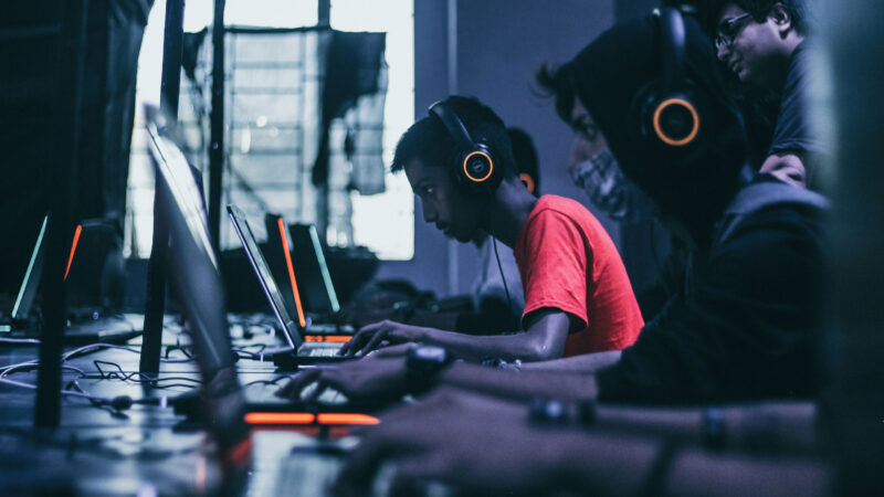 Effects of AI on young people illustrated by teenagers using computers and digital technology in a classroom